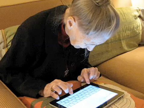 Idosa escrevendo no teclado do iPad